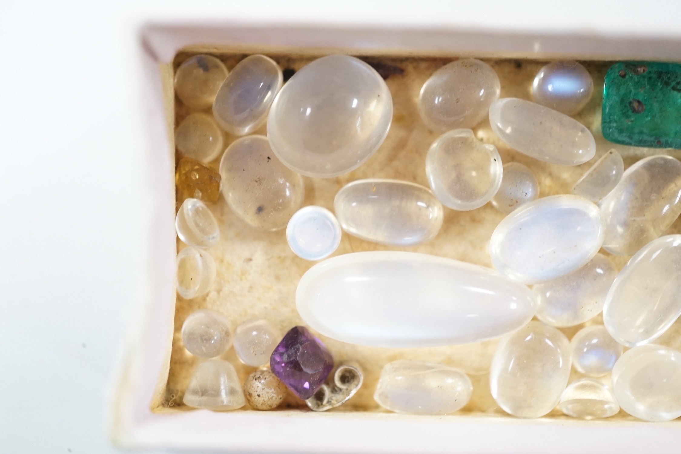 A small quantity of unmounted cabochon moonstones of varying sizes and four other unmounted coloured stones including green paste.